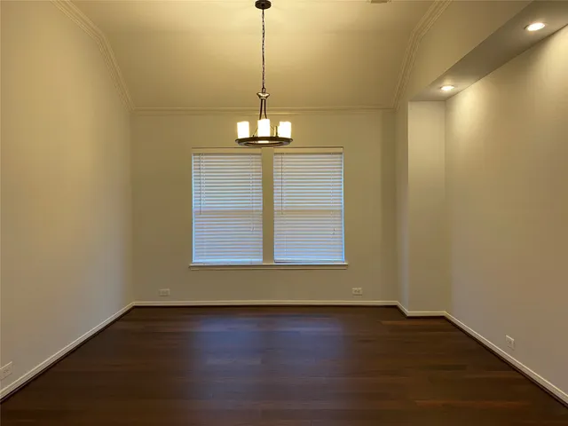 a view of a room with wooden floor chandelier and a window