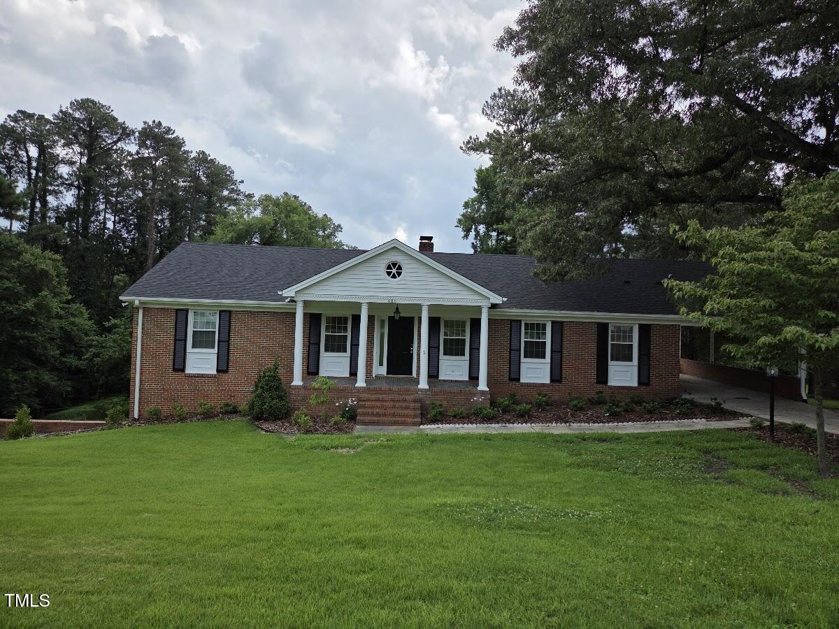 4116 Jane Lane Raleigh, NC 27604 - Photo 1 of 25 a front view of a house with a garden and trees