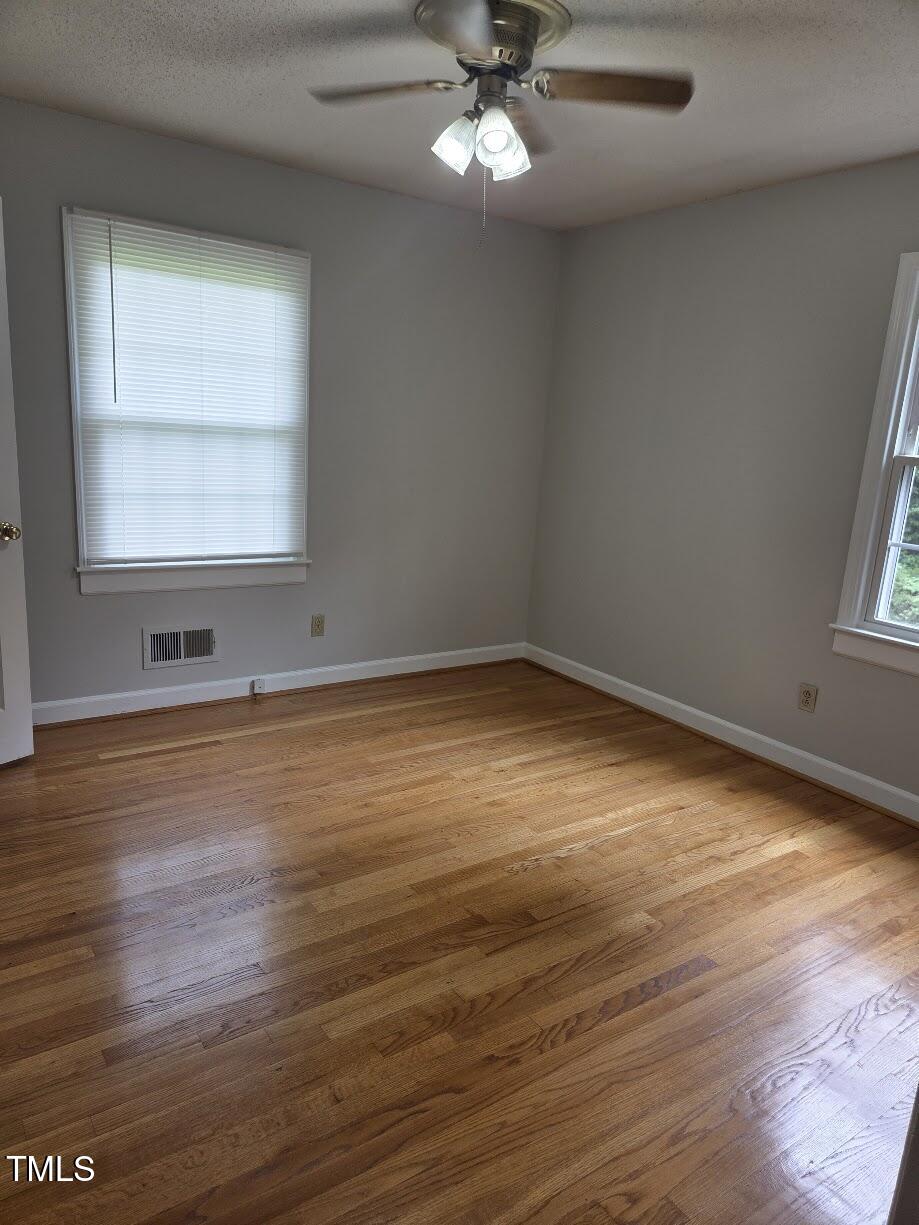 4116 Jane Lane Raleigh, NC 27604 - Photo 12 of 25 an empty room with wooden floor and windows