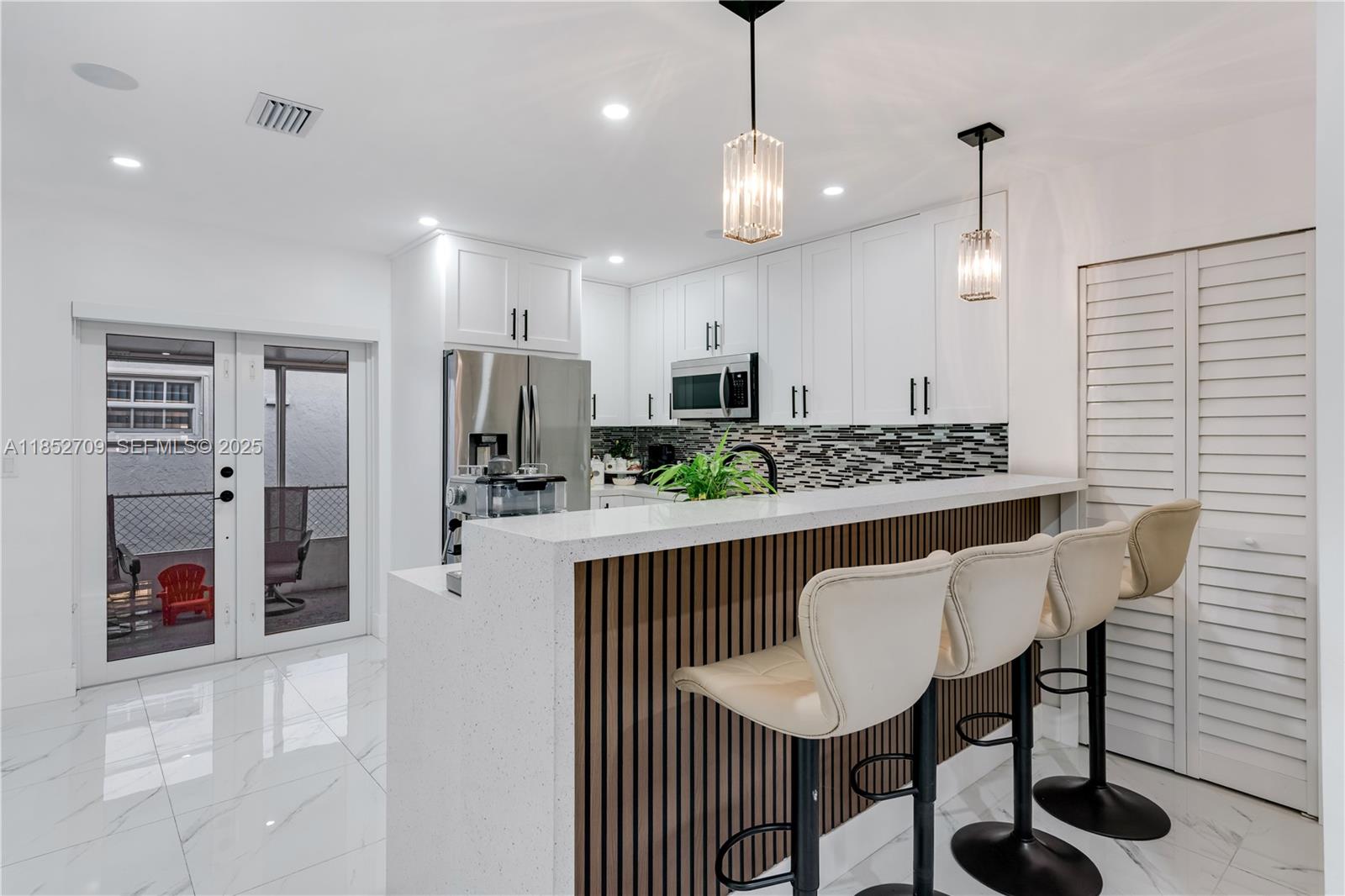 9311 Southwest 37th Street Miami, FL 33165 - Photo 16 of 39 a view of kitchen with stainless steel appliances granite countertop a table chairs and a refrigerator