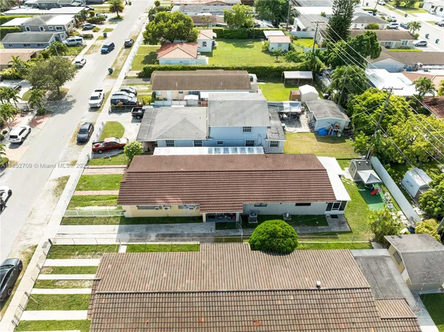 an aerial view of a house with a yard and potted plants