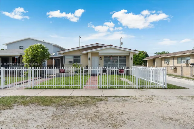 a view of a house with a small yard and wooden fence