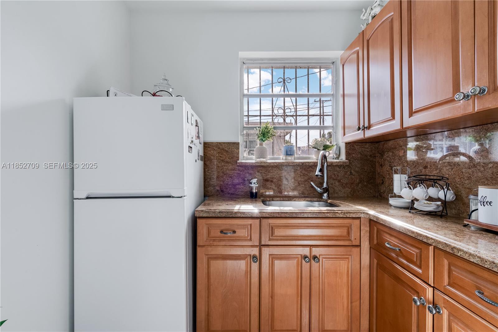 9311 Southwest 37th Street Miami, FL 33165 - Photo 10 of 39 a white refrigerator freezer sitting inside of a kitchen