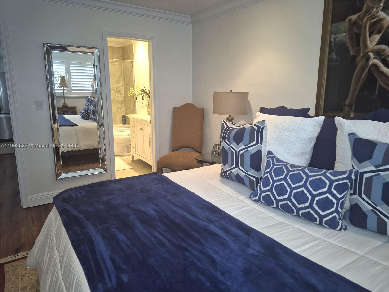 535 Hendricks Isle, Unit 306 Fort Lauderdale, FL 33301 - Photo 12 of 32 a spacious bedroom with a bed and wooden floor