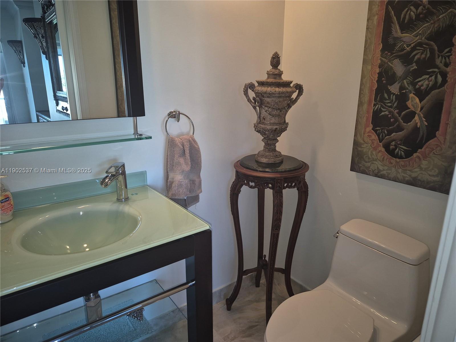 535 Hendricks Isle, Unit 306 Fort Lauderdale, FL 33301 - Photo 19 of 32 a bathroom with a sink a toilet and mirror