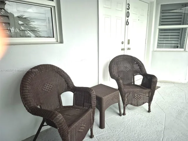 a view of a swimming pool with chairs and tables in the patio