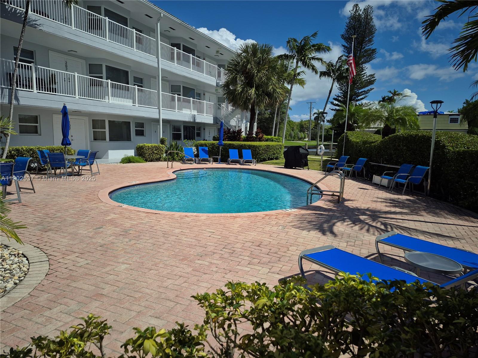 535 Hendricks Isle, Unit 306 Fort Lauderdale, FL 33301 - Photo 24 of 32 a view of a swimming pool with chairs and tables in the patio