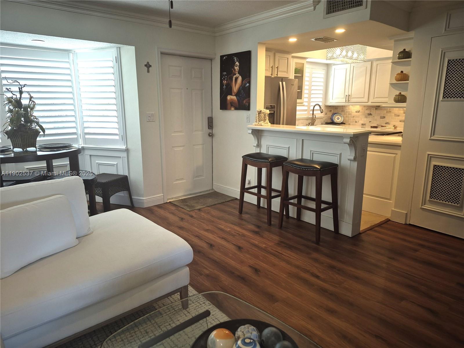 535 Hendricks Isle, Unit 306 Fort Lauderdale, FL 33301 - Photo 3 of 32 a large bedroom with wooden floor and furniture