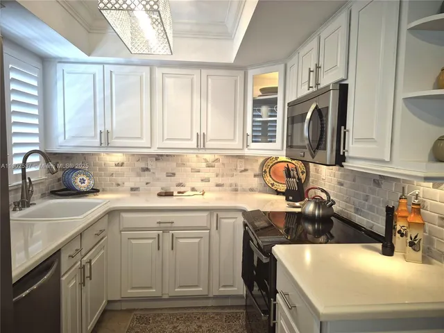 a kitchen with stainless steel appliances granite countertop a sink stove and cabinets