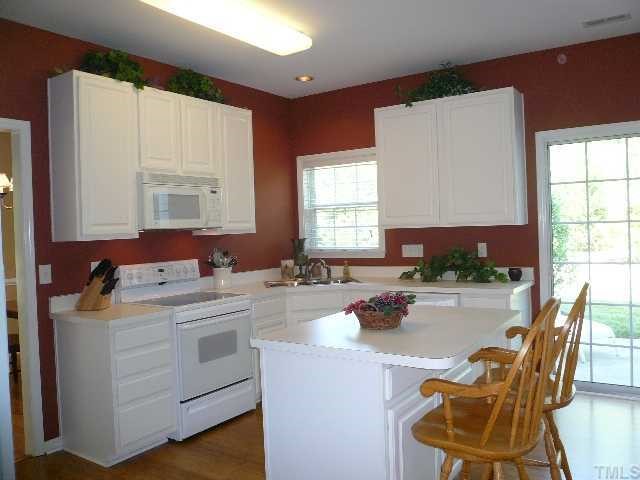 8008 Strawberry Meadows Street Raleigh, NC 27613 - Photo 4 of 12 Huge kitchen with breakfast bar, fresh paint, smooth cooktop range, BI microwave and sliding glass doors to the back patio.