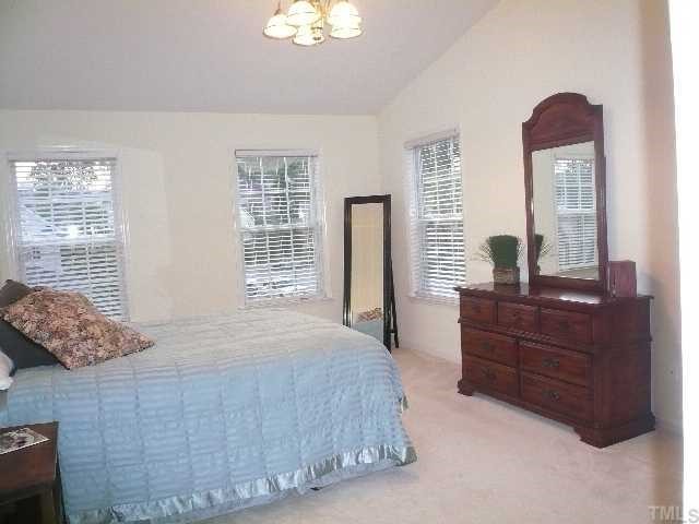 8008 Strawberry Meadows Street Raleigh, NC 27613 - Photo 7 of 12 THe master bedroom is very spacious with vaulted ceiling, fresh paint and a new brushed nickel chandelier.