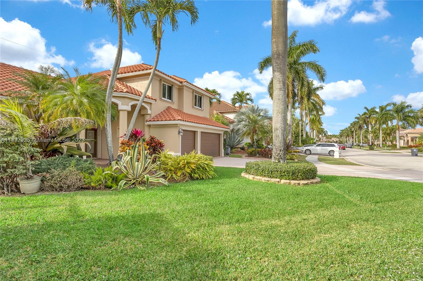 19610 Dinner Key Drive Boca Raton, FL 33498 - Photo 2 of 27 a view of a white house with a big yard and potted plants