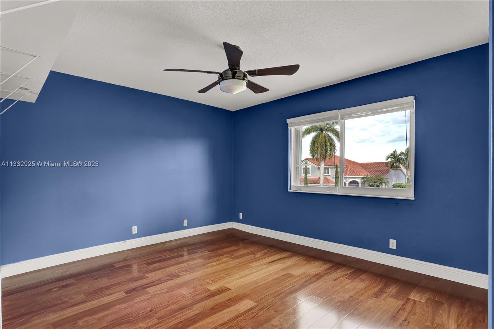 19610 Dinner Key Drive Boca Raton, FL 33498 - Photo 21 of 27 a view of an empty room with window and wooden floor