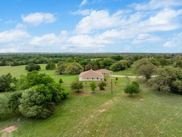 an aerial view of a houses with a yard