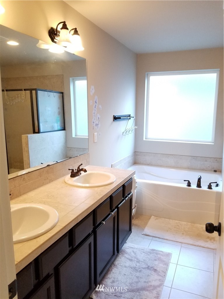 4818 155th Place Southwest, Unit 11 Edmonds, WA 98026 - Photo 13 of 30 a bathroom with a tub double vanity sink and mirror