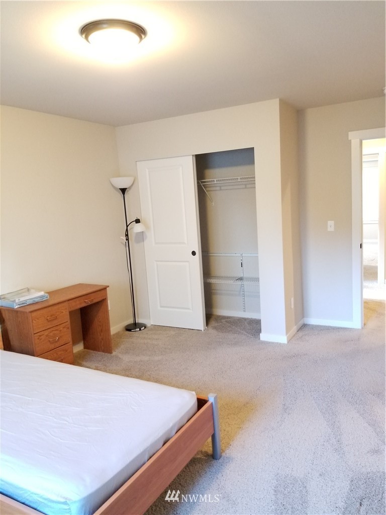 4818 155th Place Southwest, Unit 11 Edmonds, WA 98026 - Photo 14 of 30 a bedroom with a bed and a table