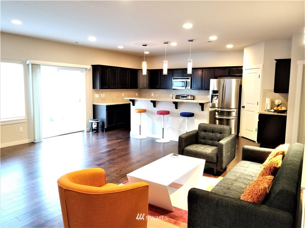 4818 155th Place Southwest, Unit 11 Edmonds, WA 98026 - Photo 5 of 30 a living room with furniture a flat screen tv and kitchen view