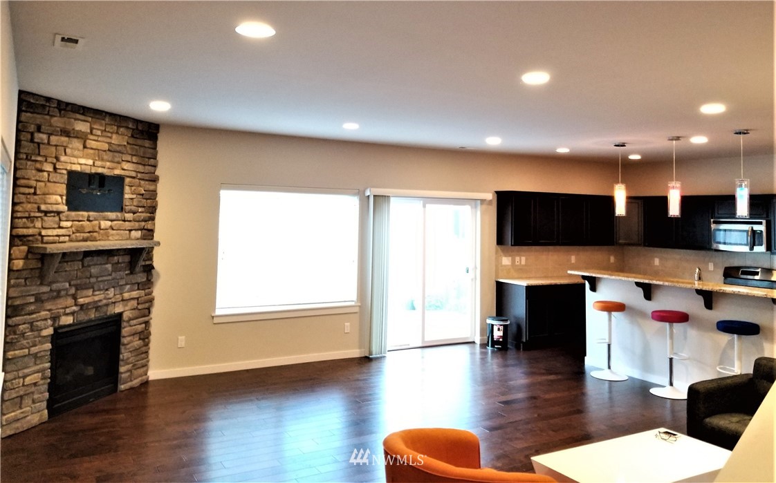4818 155th Place Southwest, Unit 11 Edmonds, WA 98026 - Photo 6 of 30 a lobby with furniture wooden floor and a fireplace