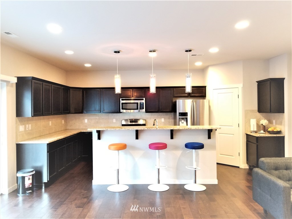 4818 155th Place Southwest, Unit 11 Edmonds, WA 98026 - Photo 8 of 30 a kitchen with a sink cabinets and wooden floor
