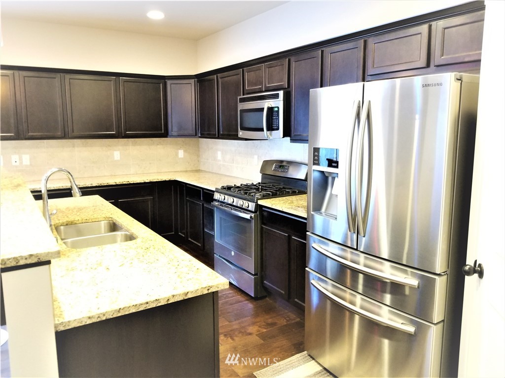 4818 155th Place Southwest, Unit 11 Edmonds, WA 98026 - Photo 9 of 30 a kitchen with wooden cabinets and stainless steel appliances