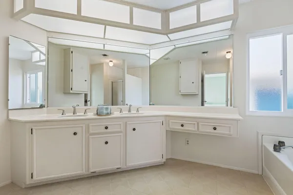 a spacious bathroom with a granite countertop sink mirror and a