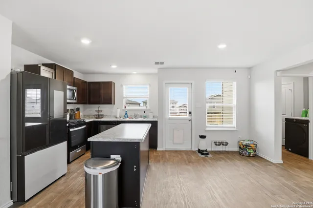 a kitchen with granite countertop a refrigerator stove and sink