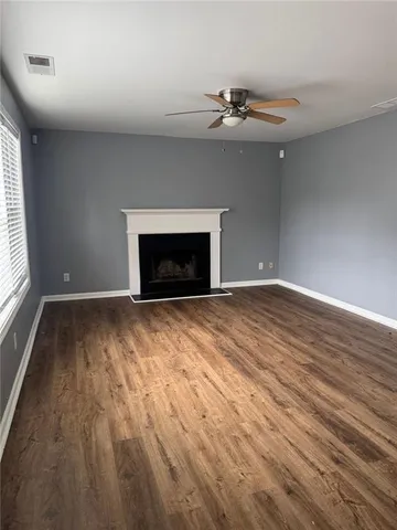 wooden floor fireplace and windows in an empty room