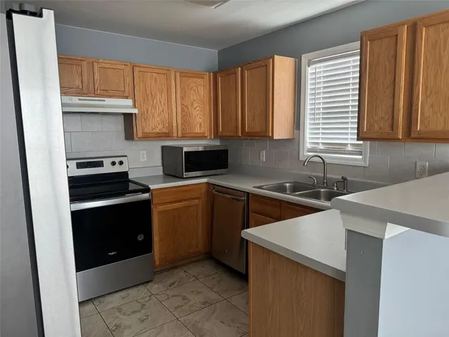 a kitchen with a sink stove top oven and cabinets