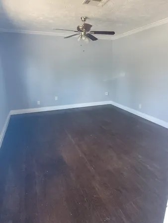 an empty room with a window and a fan