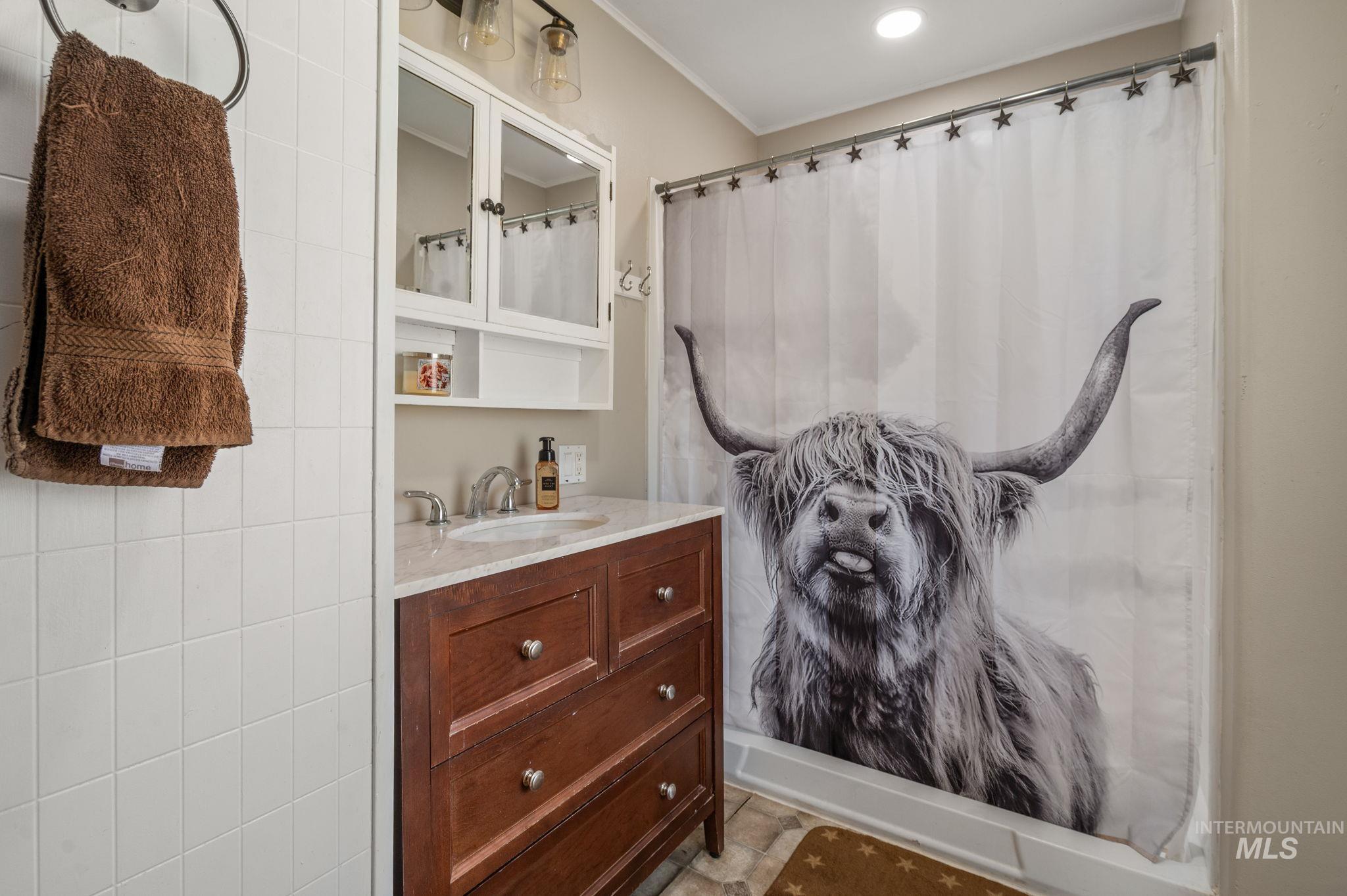 2208 4th Avenue Clarkston, WA 99403 - Photo 12 of 27 Bathroom featuring vanity, curtained shower, and ornamental molding