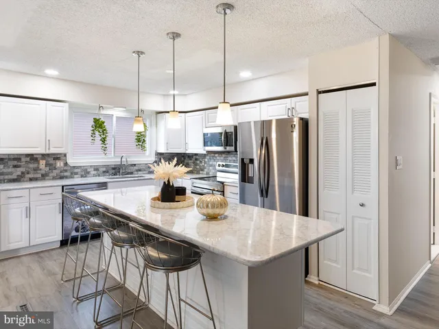 a kitchen with kitchen island a counter and chairs