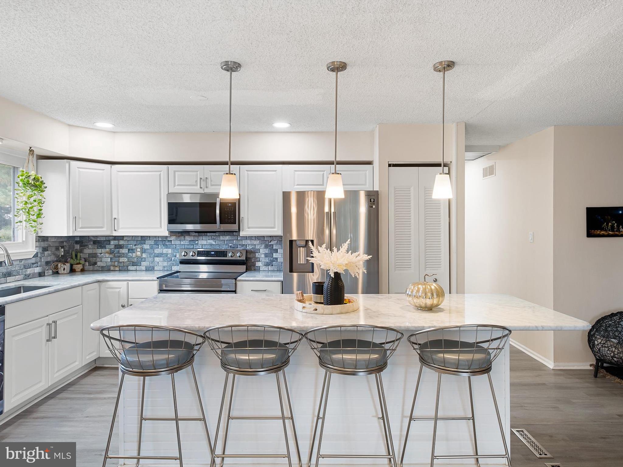 74 Valley Forge Road New Castle, DE 19720 - Photo 16 of 30 a kitchen with stainless steel appliances kitchen island granite countertop a stove a sink a microwave and a refrigerator