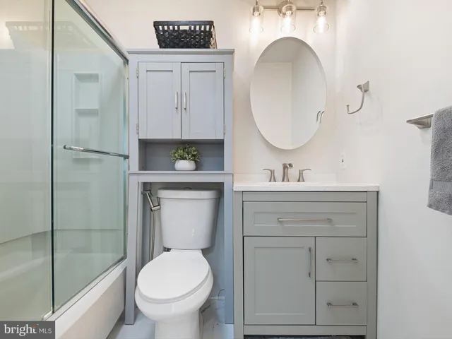 a bathroom with a toilet a sink a mirror and vanity