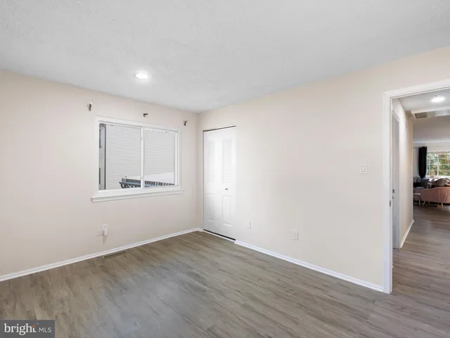 a view of a room with wooden floor and a window