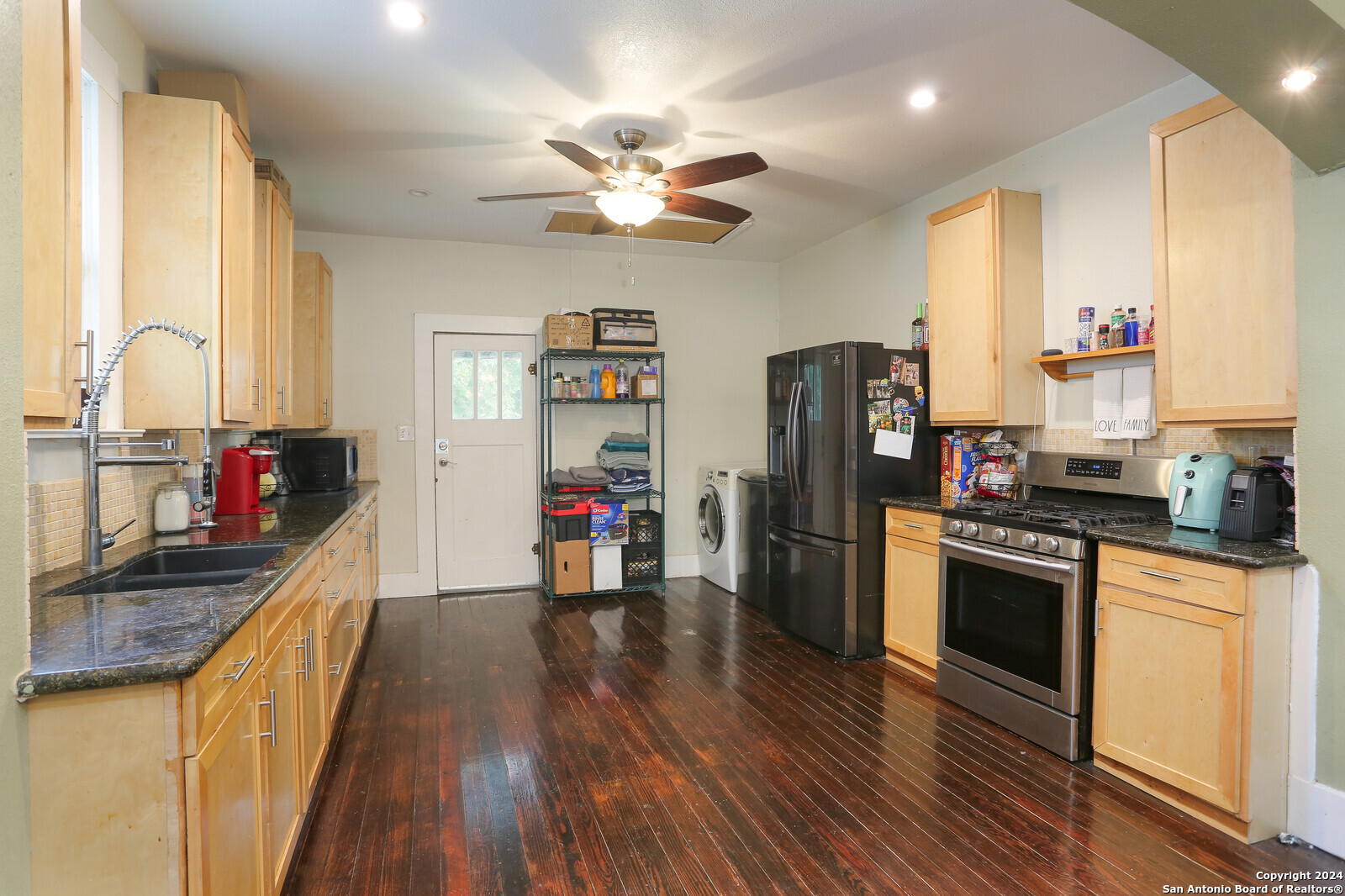 511 Devine Street San Antonio, TX 78210 - Photo 9 of 28 a kitchen with stainless steel appliances a stove top oven a refrigerator cabinets and wooden floor