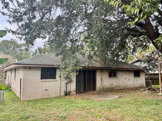a view of a house with a yard and large tree