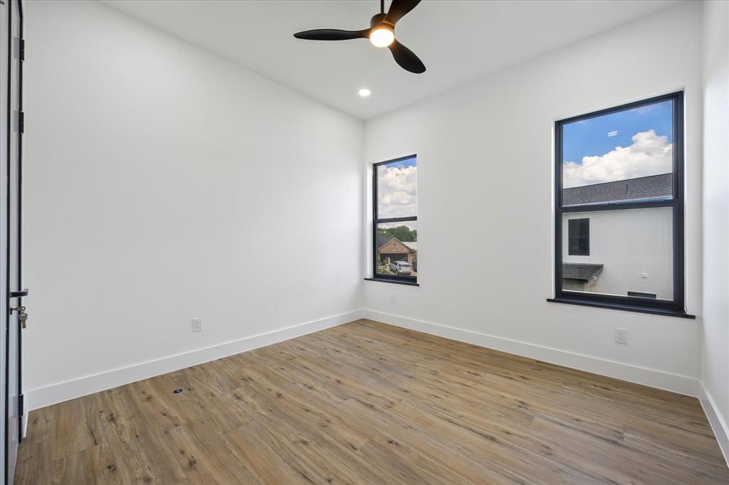 2811 Rodeo Drive Quinlan, TX 75474 - Photo 24 of 38 a view of an empty room with wooden floor and a window