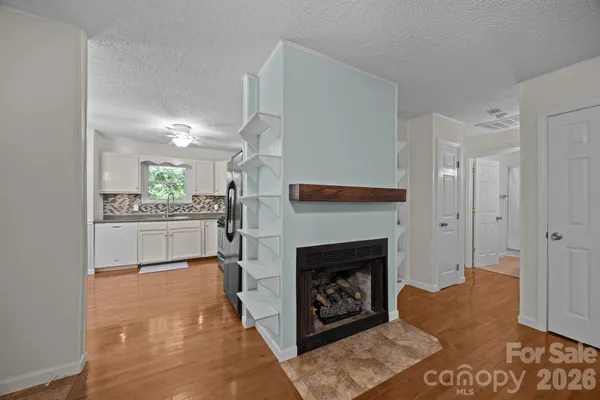 a kitchen with stainless steel appliances granite countertop a refrigerator a sink dishwasher a stove and white cabinets