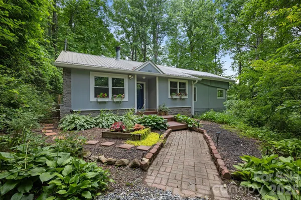 a front view of house with yard and trees around