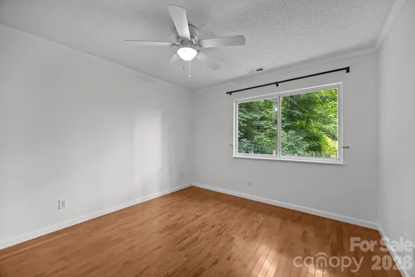 an empty room with a window and wooden floor
