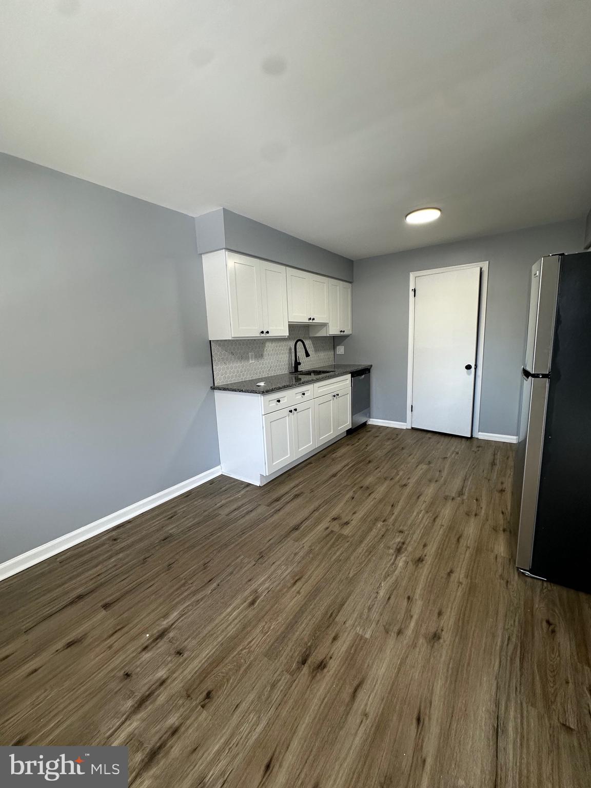 612 North Shady Retreat Road, Unit 14 Doylestown, PA 18901 - Photo 15 of 17 a kitchen with granite countertop wooden floors and white stainless steel appliances