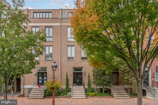 a front view of a house with a tree