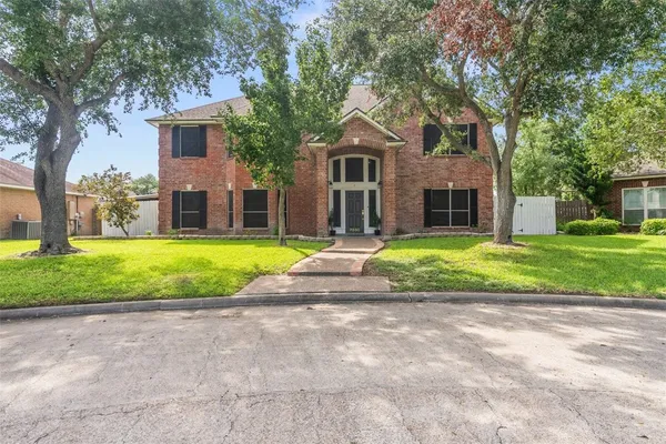 a view of a house with a big yard and large trees