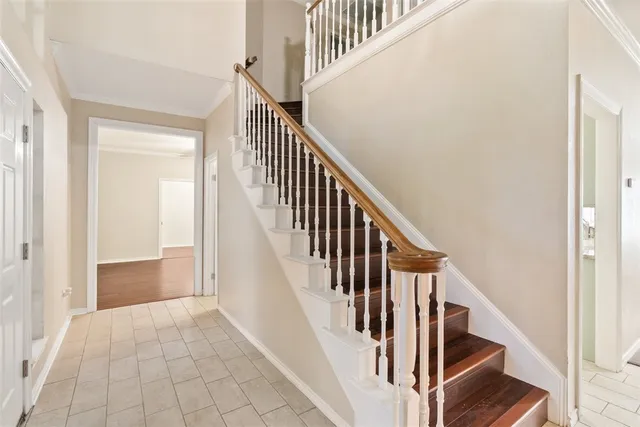 a view of staircase with wooden floor and white walls