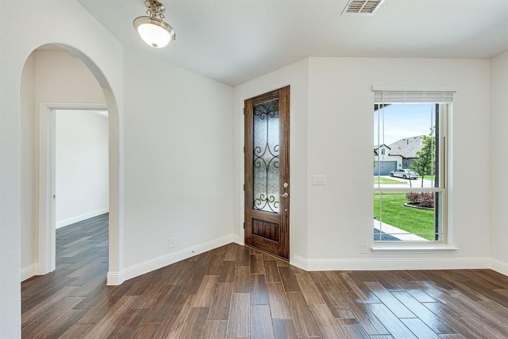 2133 Devonblue Drive Forney, TX 75126 - Photo 13 of 34 an empty room with wooden floor mirror and windows