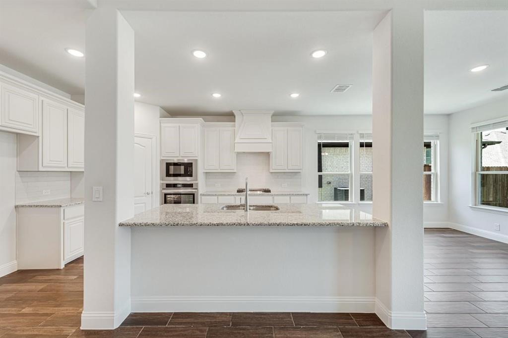 2133 Devonblue Drive Forney, TX 75126 - Photo 7 of 34 a kitchen with kitchen island granite countertop a sink and cabinets