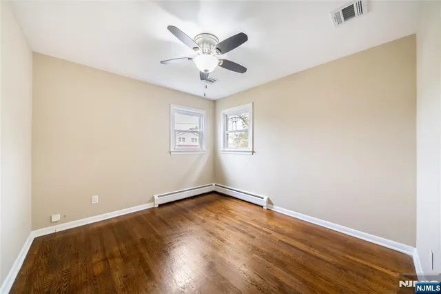 an empty room with a window and a ceiling fan
