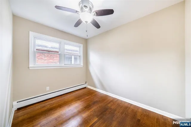 an empty room with a window and a ceiling fan