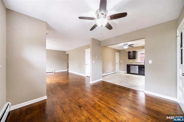 a view of empty room with wooden floor and window