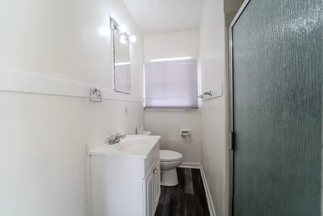 a bathroom with a sink and mirror with toilet